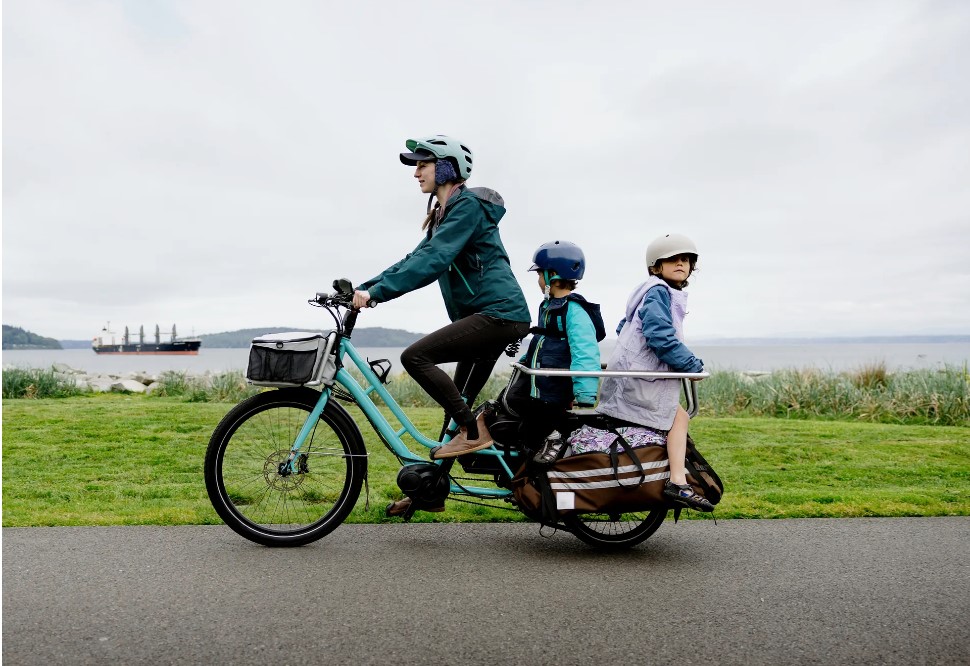 cargo e-bike with a basket on the front and a child seat on the back